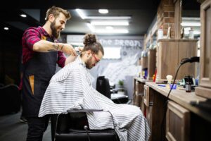 young bearded man getting haircut by hairdresser w 2022 02 02 04 49 04 utc